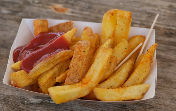 Gesundheitsrisiken durch falsche Ern&auml;hrung: Fettige Pommes frites mit Ketchup als Symbol f&uuml;r Fast Food, &Uuml;bergewicht und ungesunden Lebensstil