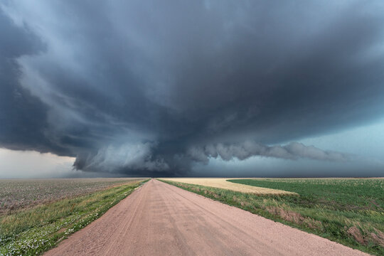 A massive storm at the end of a remote dirt road across Tornado Alley in the Midwest USA