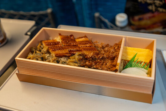 Shinkansen ekiben Fukagawa-meshi featuring grilled anago conger eel over rice with asari clams, gobo and tamagoyaki sweet egg omelet. Ekiben is a popular Japanese bento box sold at train stations. 