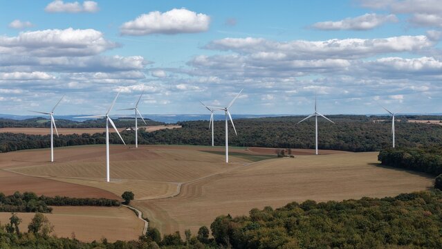 vue a&eacute;rienne panoramique du parc &eacute;olien d'Ottange en Moselle. Les &eacute;oliennes en fonction ressortent sur un ciel bleu nuageux, au milieu des champs labour&eacute;s et entour&eacute;s de for&ecirc;ts. France 2026