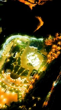 Vertical video. Gelendzhik, Russia. Cathedral of St. Andrew the First-Called, snow-white walls and golden domes illuminated against the night, Drone footage over Andreevsky park and the Black Sea coa