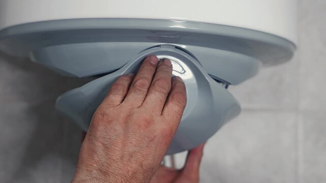 Professional plumber performing electric water heater installation and connecting household water supply pipes