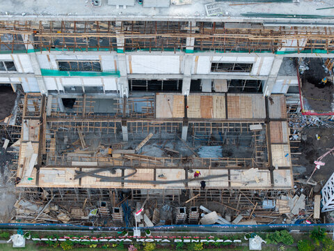 Aerial view of the construction site of the Wangaya Regional General Hospital emergency room wing with workers and scaffolding in Kecamatan Denpasar Utara, Bali, Indonesia.
