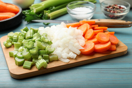 Fresh celery, carrots, onions and spices on light blue wooden table, closeup