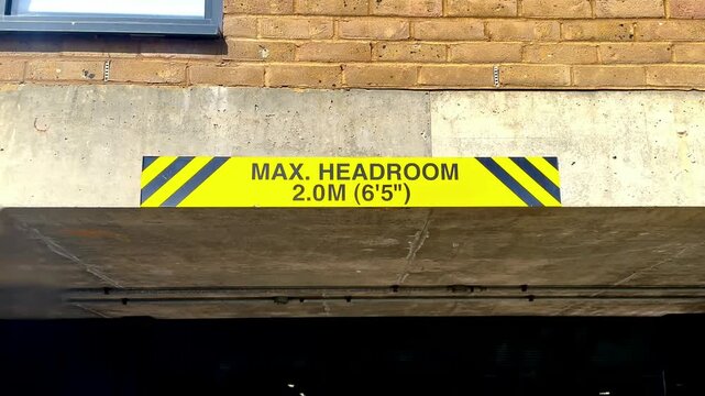 max headroom sign vehicle transport yellow and black entry barrier on building