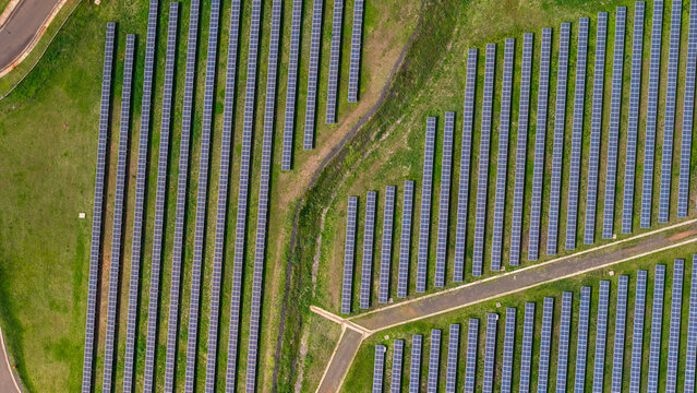 Aerial view of rows of solar panels installed on a green field, showcasing renewable energy infrastructure in Posadas, Misiones Province, Argentina.
