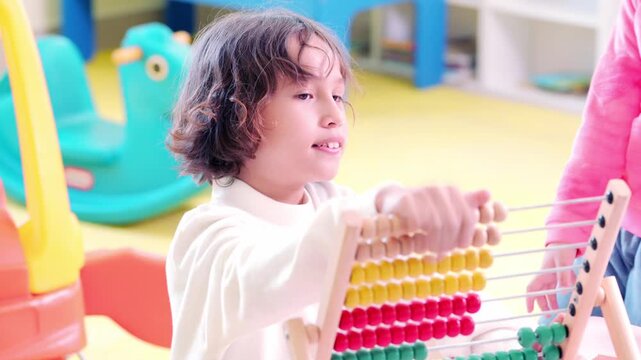 Happy schoolboy focus education learning playing with colorful abacus frame classroom enjoying math counting child development foundational skill