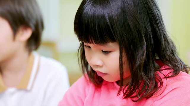 Focused child engaged in education learning activity with curious happy emotion during classroom session at elementary school girl boy studious look
