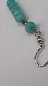 Handmade earring with natural amazonite gemstone beads on jewelry display stand, advertising shot for jewelry brand