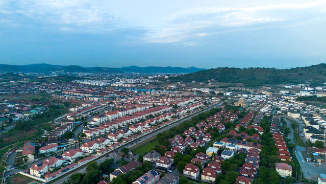 Aerial view of a residential neighborhood with rows of houses featuring red-tiled roofs and paved roads in Abuja, Federal Capital Territory, Nigeria.