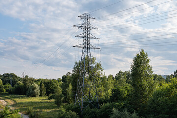 krajobraz linii elektrycznej pośrodku zielonych pól w zachodniej Polsce, jasne zielono niebieskie kolory lekko pochmurna pogoda © mbugajsky