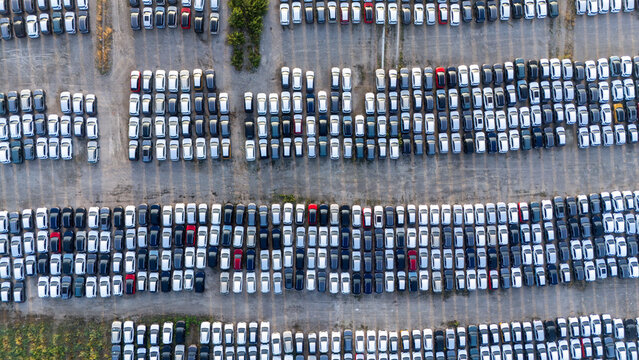 Piacenza, Emilia-Romagna, Italy - 01 August 2026: Aerial view of a car parking factory yard filled with rows of new vehicles, showing organized parking lanes and industrial infrastructure.