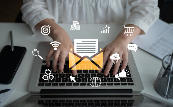 Hands Typing on Laptop Keyboard Surrounded by Digital Communication Icons Symbolizing Email Marketing and Online Business Strategies. Glyphic.