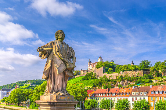 Wurzburg, Germany, July 14, 2024: Br&uuml;ckenstatue Saint Kolonat Colonatus statue on Old Main Bridge, Marienberg Fortress Festung on Mary's Mount hill in Wurzburg old town, city historical center Mitte