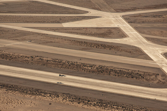 Yuma, United States - 27 March 2025: Aerial view of a military aircraft on the runway at Marine Corps Air Station Yuma, surrounded by arid desert landscape and intersecting concrete taxiways.