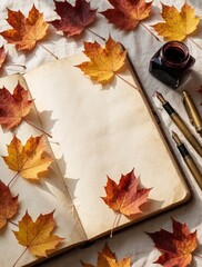 Obraz premium Autumn flat lay with open blank journal on white cloth. Colorful maple leaves, vintage fountain pens, ink bottle decorate empty notebook. Top view of stationery for poetry, calligraphy creative