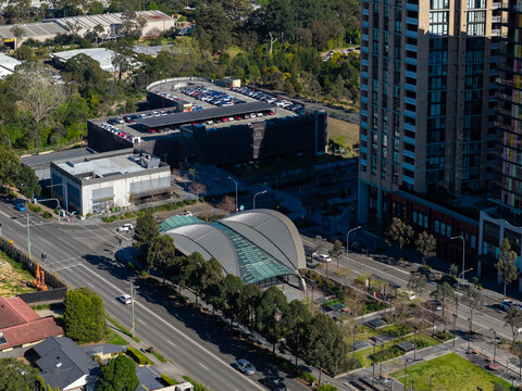 Castle Hill, New South Wales, Australia - 15 September 2026: Aerial view of Hills Showground Station with its curved roof, modern apartment buildings, and parking structure in the Sydney suburbs.