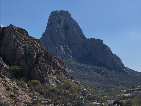 San Antonio de la Cal, Mexico - 14 September 2026: Aerial view of the iconic Pena de Bernal monolith rising above the rugged landscape with rocky slopes and sparse vegetation.