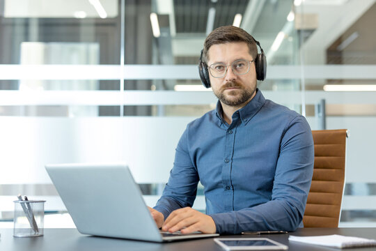 Remote work and customer support, professional man with headset working on laptop in modern office for business communication and virtual meeting