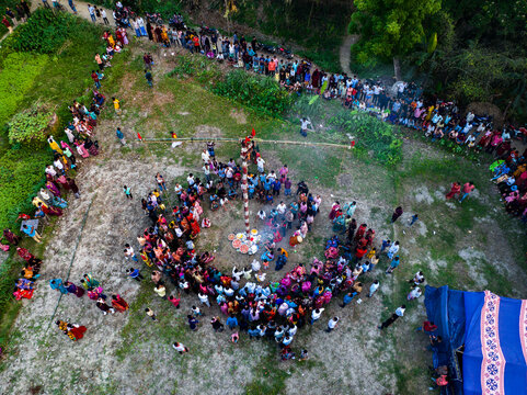 Dhamrai, Bangladesh - 13 April 2024: Aerial view of a large crowd gathered around a central pole during a traditional festival, with people observing the ceremony.