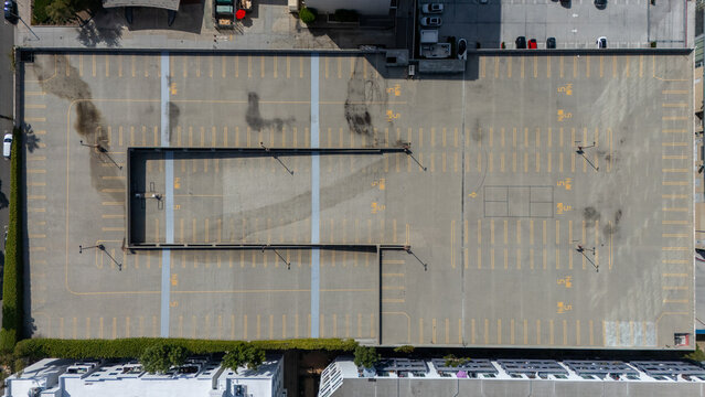 Los Angeles, United States - 13 September 2026: Aerial view of the empty parking lot at Miracle Mile featuring yellow painted stalls, speed limit markings, and surrounding urban buildings.