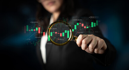 Businesswoman Analyzing Stock Market Trends with Magnifying Glass on Digital Graphs and Charts in...