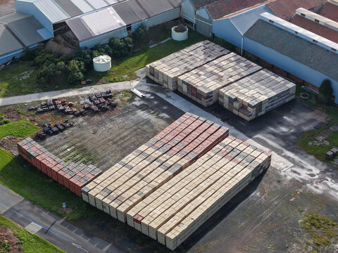 Scoresby, Victoria, Australia - 09 September 2026: Aerial view of PGH Bricks Pavers Selection Centre with large stacks of bricks stored in an industrial yard near metal-roofed warehouses.