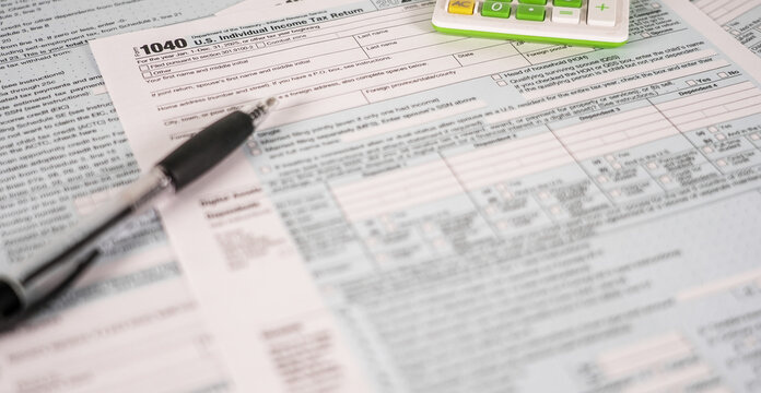 US Individual Income Tax Return Form 1040 with Pen and Calculator Representing Finance and Taxes