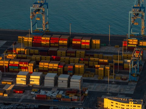 Civitavecchia, Italy - 23 August 2026: Aerial view of Civitavecchia Port with colorful shipping containers, large gantry cranes, and the calm sea in the background.