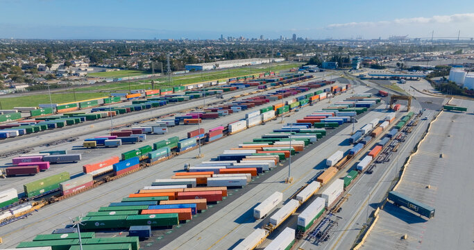 Los Angeles, United States - 28 August 2026: Aerial view of a busy intermodal rail terminal filled with colorful shipping containers and freight trains.