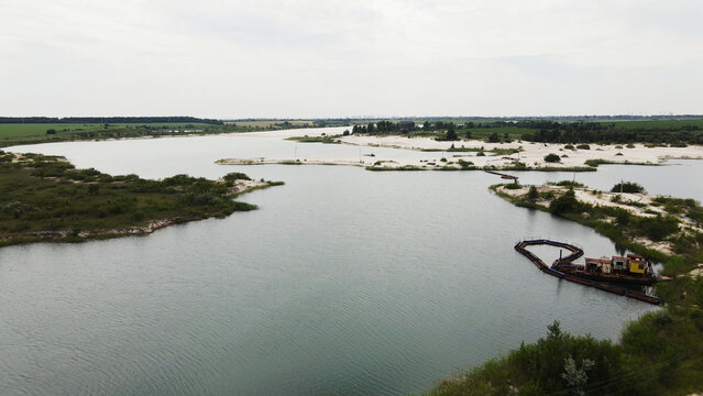 Industrial sand dredging operation in a shallow lake, extracting sand from the waterbed, shaping the landscape