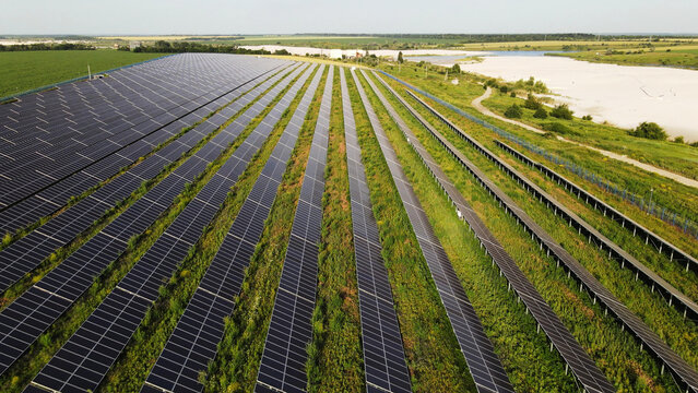 Solar farm generating electricity from sunlight in a rural field, promoting sustainable green energy