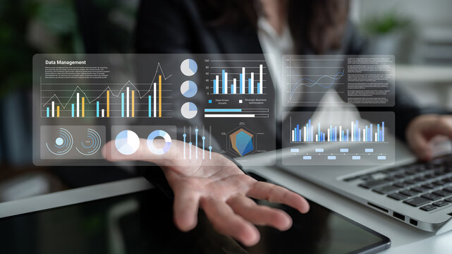 A business professional evaluates data management metrics displayed on a digital interface while seated at a sleek office desk with a laptop. Gantry