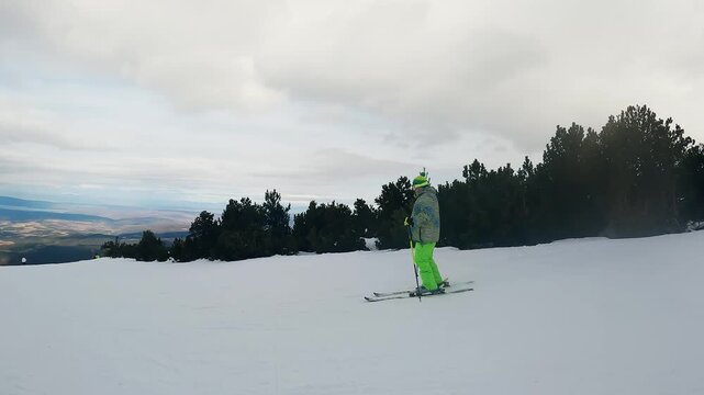 Skier dressed in neon green pants navigates a snowy slope in Borovets, Bulgaria