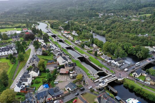 Aerial view of the Fort Augustus Locks on the Caledonian Canal, featuring stone lock chambers, village buildings, and green hills in Fort Augustus, Scotland, United Kingdom.