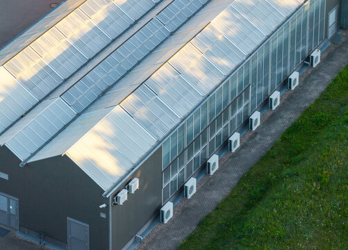 Aerial view of Adam Mickiewicz University Morasko Campus featuring a modern building with a gabled roof and air conditioning units in Poznan, Greater Poland Voivod, Poland.