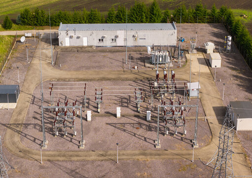 Aerial view of an electrical substation with transformers, switchgear, and a control building surrounded by a fence in Pomeranian Voivodeshi, Poland.