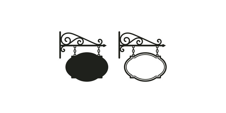 Decorative hanging oval sign boards with ornamental iron brackets for shop advertising.