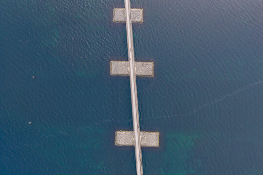 Aerial view of Lepsoy bridge crossing the deep blue waters with stone piers visible in Haram, More og Romsdal, Norway.