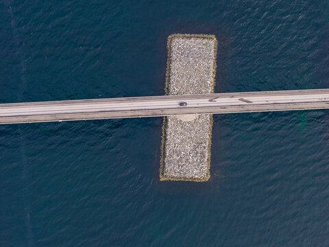 Aerial view of Lepsoy bridge crossing the deep blue waters with a stone pier foundation in Haram, More og Romsdal, Norway.