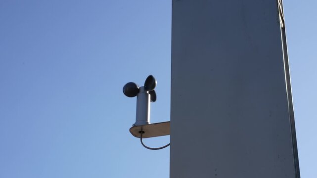 Weather Sensor Anemometer Mounted On Building Structure Against Blue Sky