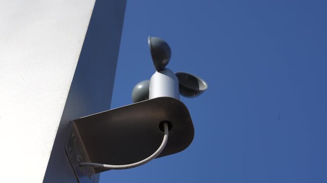 Weather Station Anemometer Sensor Mounted On Building Against Blue Sky