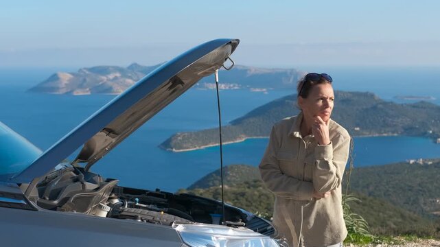 Stressed woman standing by a broken car with open hood. Upset and confused woman standing on the side of the road with a car breakdown, anxiously trying to understand the engine problem