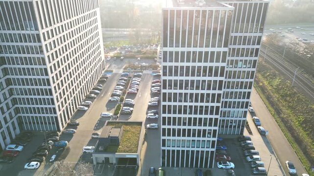 Aerial view of modern office buildings with sun flares illuminating the scene, showcasing architectural design and urban environment. Business district and contemporary city landscape at sunset time