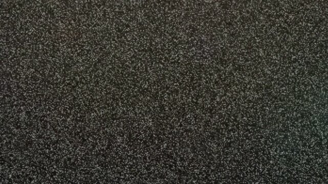 Abstract dark grey grainy texture with subtle shimmering particles moving across the screen
