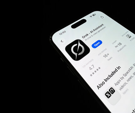 Close up of Grok AI assistant app page on smartphone screen with app rating and developer details, illustrative editorial
