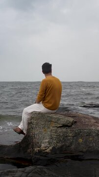 Man Relaxing on a Beach in Helsinki on a Cloudy Day