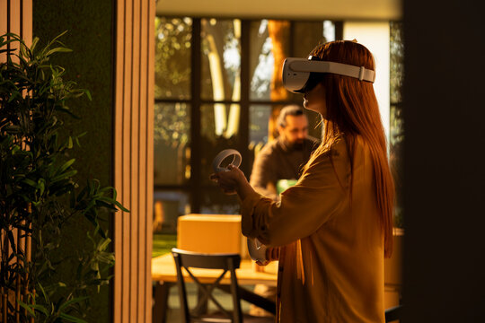 Overjoyed woman uses VR glasses to simulate her first-home interior layout, exploring property design ideas and floor-plan visualization during relocation.