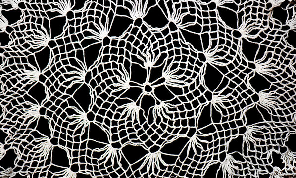 Crochet lace patterns background, crocheted Grandma's Doily, detail of hand-crocheted embroidery, tablecloth, napkin isolated on black background backdrop art design. Craft, vintage linen. Flat lay. 