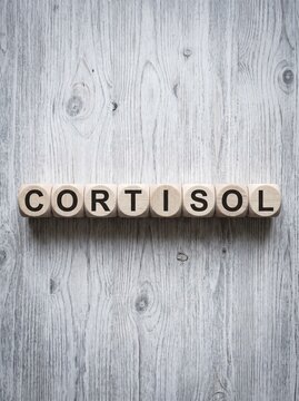 Cortisol  concept word spelled out with wooden blocks on a white rustic wooden background
